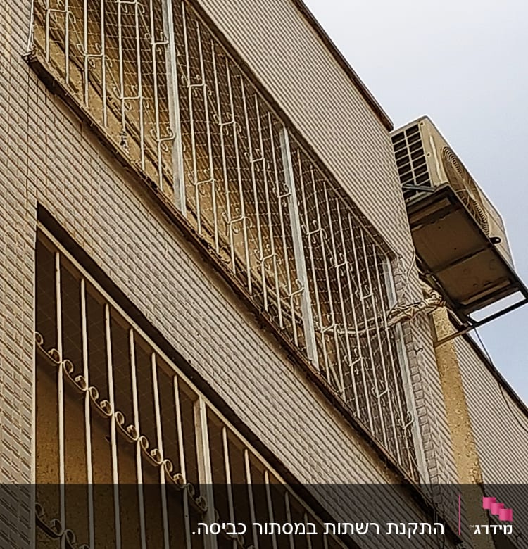 סורגים על חלונות בניין עם רשת למניעת יונים
